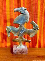 Full view of brass horse sculpture on marble base