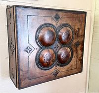 Front view of cabinet showing embossed leather and domed panels