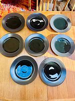 Top view of all eight two-tone black plates on table