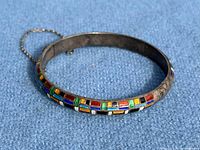 Full view of sterling silver enamel bangle showing geometric pattern and safety chain