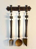 Entire wall hanging showing bracket and three utensils