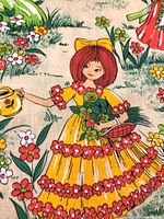 Close view of fabric pattern showing garden girl, flowers and watering can