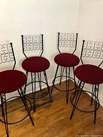 Set of four wrought iron bar stools in corner view