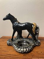 Front view of ceramic horse ashtray showing overall form and metal insert