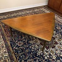Top view of triangular teak coffee table on rug
