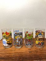 Front view of all four glasses showing characters and logos