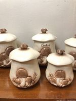Front view of five ceramic mushroom canisters