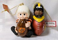 Front view of both ornaments showing team logos, tags, and hanging cords