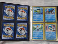 Open binder showing card backs and four visible cards