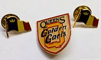 Front view of all three Queen's Golden Gaels lapel pins