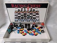 Open box showing all racing-themed chess pieces, tyres, flags and cars