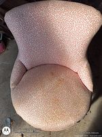 Top view showing pink vine-pattern upholstery and spoon-back shape