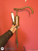 Full view of copper and brass sink tap fixture held in hand