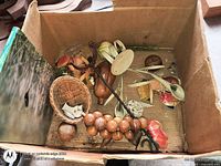 Top view of box showing assortment of wooden beads, metal rod, wicker basket and plastic parts