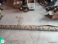 Rolled antique rug on floor