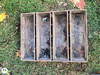 Top view of rectangular four-section metal tray showing rust and wear