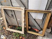 Two wooden picture frames, one white painted, one gold-tone