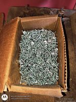 Top view of open box filled with silver-tone screws