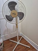 Full view of Hampton Bay pedestal fan showing base, pole, cage and blades