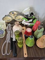 Group view of mixed kitchen utensils, shakers, dishware on tabletop
