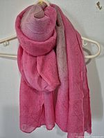 Full view of pink silk shawl draped on hanger