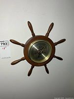 Front view of wooden ship wheel barometer on wall