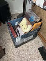 Box with books, cribbage boards, Scrabble box partially visible