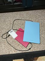 Samsung tablet and Kobo eReader with cable on carpet