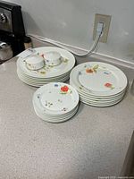 Stacked small, medium and large plates with salt and pepper shakers visible