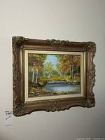 Framed oil on board painting hung on wall