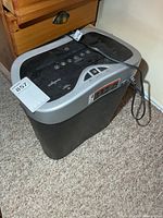 Full view of Omnitech shredder showing top controls, power cord and bin