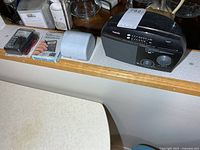 Group shot of radio, two multimeter packages and Omron blood pressure cuff case