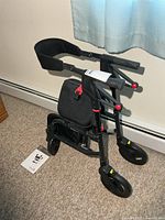 Side view of folded Nexus walker and manual on floor