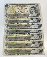 Stacked view of eight Bank of Canada $1 bills showing fronts and serials