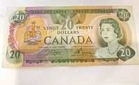 Front view of Canadian $20 bill showing full design, portrait, coat of arms and denominations