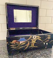 Box open showing interior mirror and felt lining