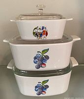 Stacked view of three casserole dishes showing motifs and lids