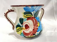 Front view showing floral motif and dual handles