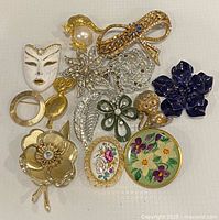 All brooches laid out showing variety of styles and finishes
