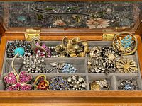 Open jewelry box showing all costume jewelry pieces neatly in compartments