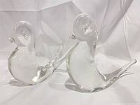 Both clear glass bird figurines side by side front view