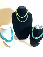 Group view of all four necklaces on display stands