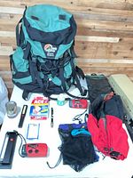 Backpacking gear laid out including Lowe Alpine pack, accessories