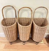 Front view of three wicker baskets side by side on rolling bases