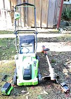 Mower, string trimmer, battery and charger laid out
