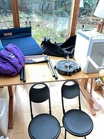 Overall view of camping items on table including chairs, pad, sleeping bag, cooler
