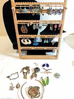 Overall view of rack with earrings and loose brooches and pins on table
