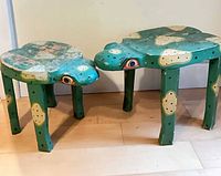 Two green frog-shaped wooden tables side by side