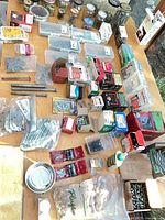 Overview of table with assorted hardware in boxes, bags and organizers