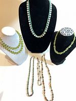 Full lot with seven necklaces displayed on busts and laid flat